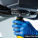 혼다 오디세이의 소모품 관리 - A detailed close-up of a car engine bay focusing on a technician’s hands wearing blue gloves pouring...